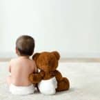 Bébé et ourson en peluche de dos en couche culotte