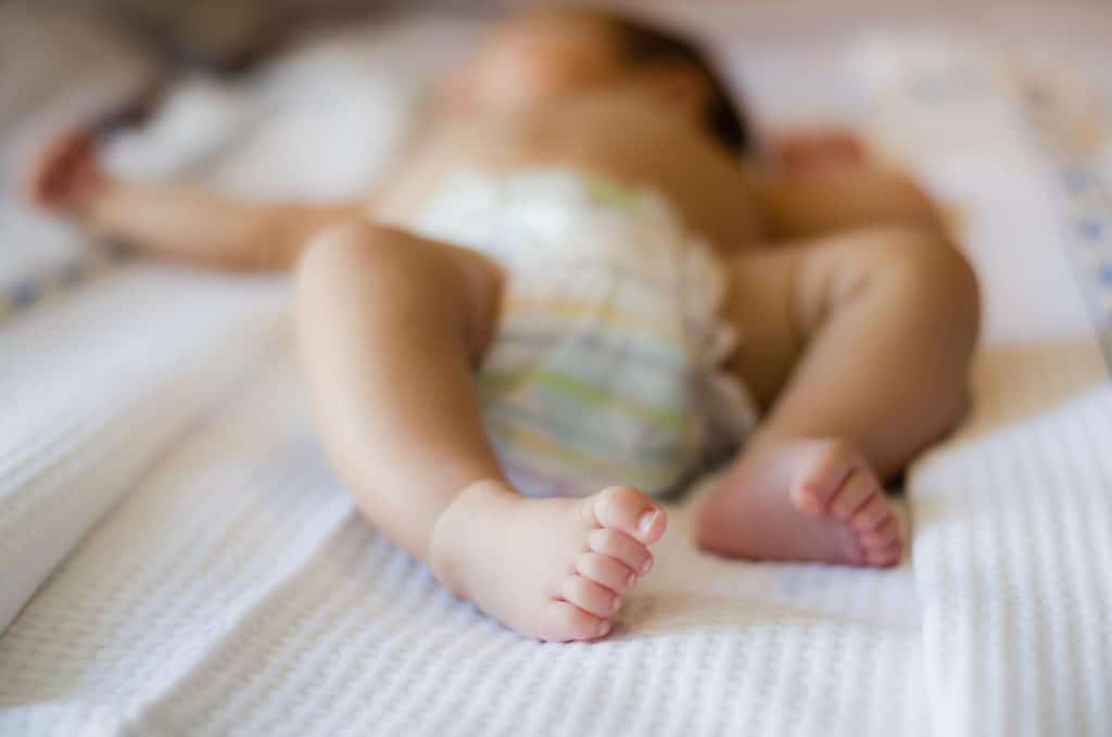 nourrisson allongé sur un lit en couche